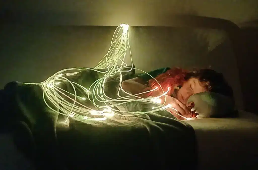 Enfant apaisé sous des fibres optiques lumineuses dans un coin calme