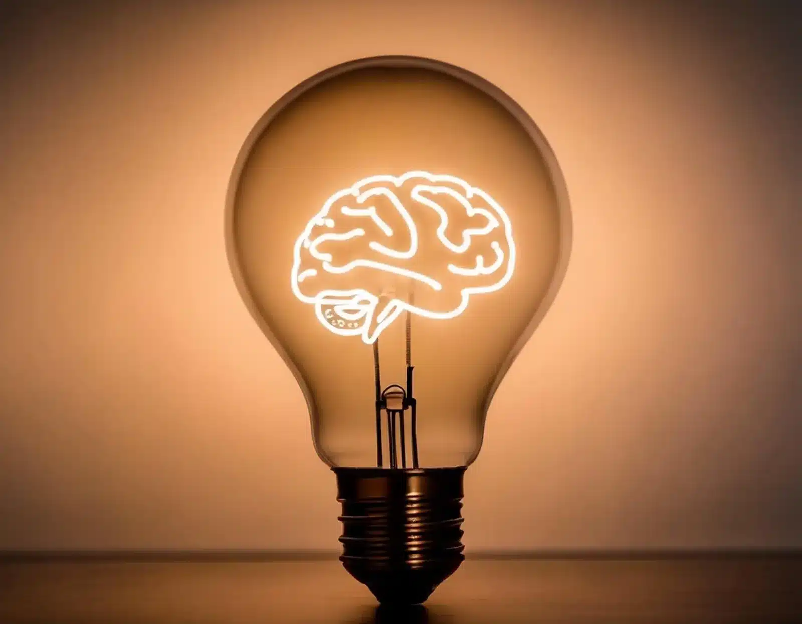 Ampoule lumineuse avec un cerveau dessiné en filament, symbole des intelligences multiples