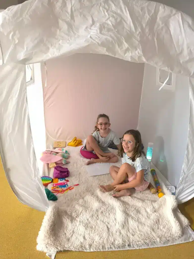 Deux enfants souriants installés dans un cocon douillet